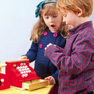 Børn der leger med Le Toy Vans Honebake kasseapparat legetøj i træ fra Legetøj Online