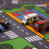 Closeup af Le Toy Van legetøjsbiler på trafiktæppet til biler